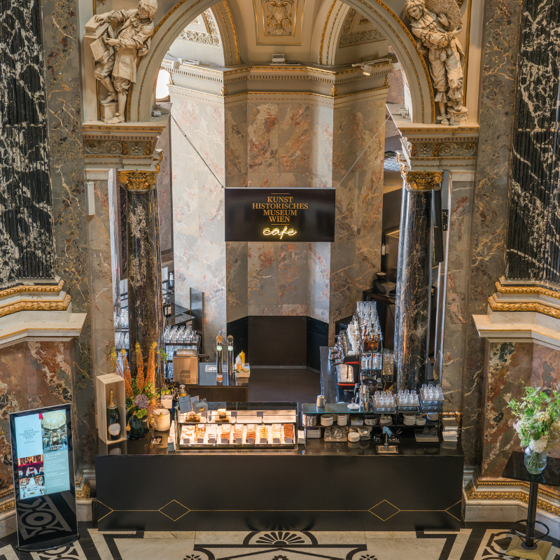 Ansicht auf die beleuchtete Cafétheke im Café des Kunsthistorischen Museums Wien mit Blick auf die Tortenvitrine